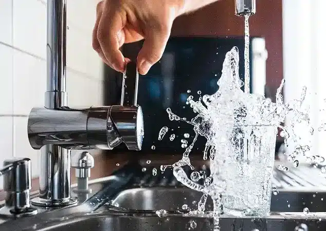 Plumber repairing a kitchen faucet